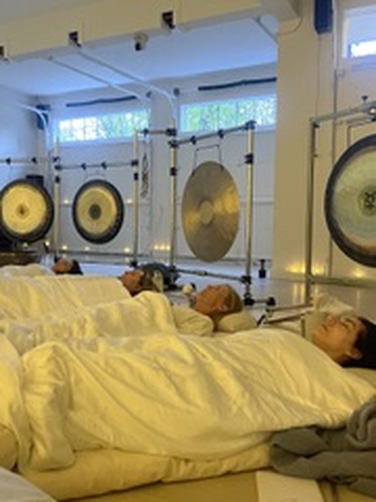 Participants resting beneath the gongs